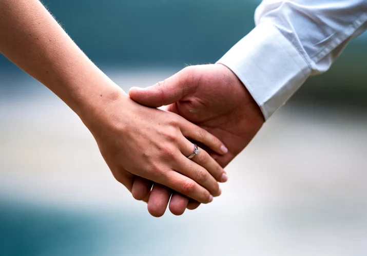 holding hands with engagement ring on