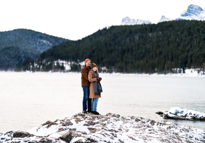 Man hugs his fiancee from behind on their Banff Engagement Session.