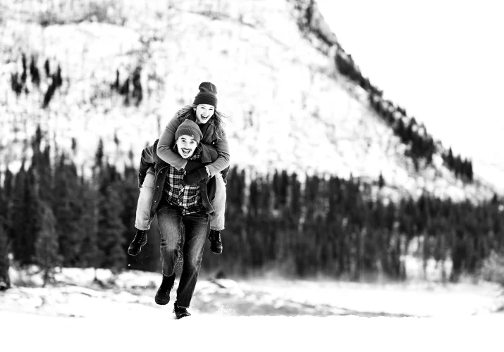 Fun engagement moment of the man running with his fiancee on his back.