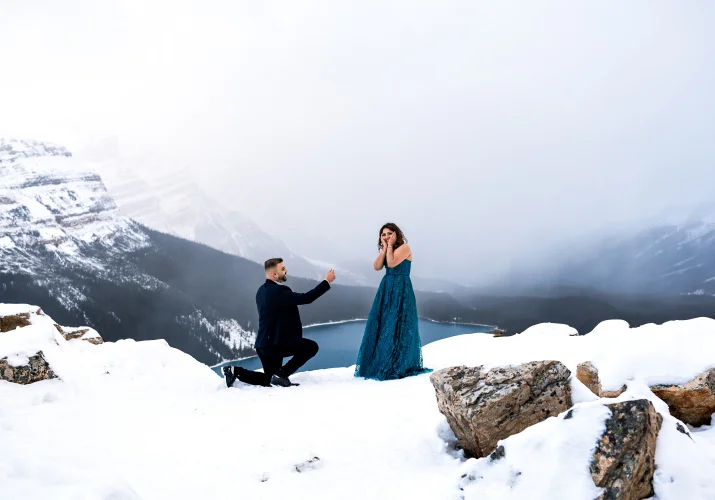 Man goes down the knee with the engagement ring and propose in the Canadian Rockies