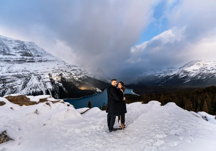 Banff Engagement Photography of the couple in a hug against rocky mountains.