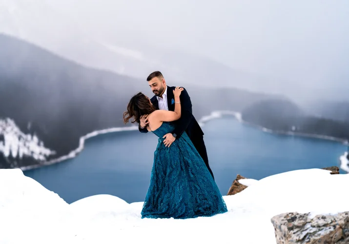 Well dressed engaged couple dance at Payto Lake during winter.