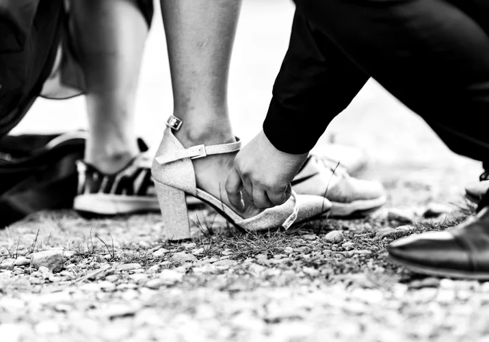 Man helps his fiancee whith the shoe.