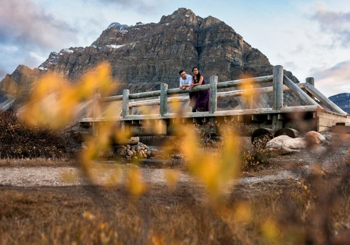 Engagement photography of the couple in the wooden bridge during fall in the Canadian Rockies.