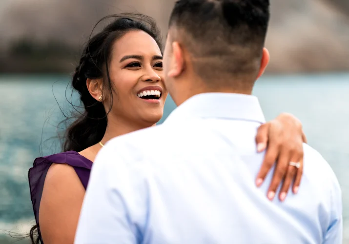 Youn lady looks with love at her fiancee and smiles.