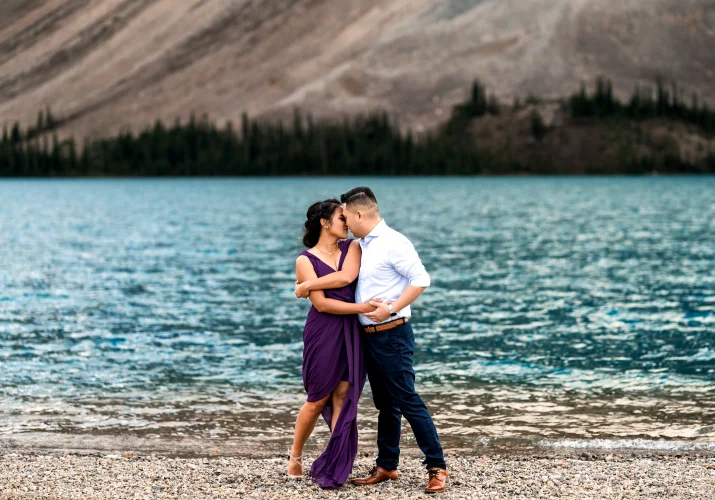 Engaged couple dance at Bow Lake and put their foreheads together.