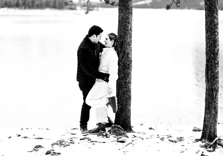 Banff lovers lean over the tree and hug