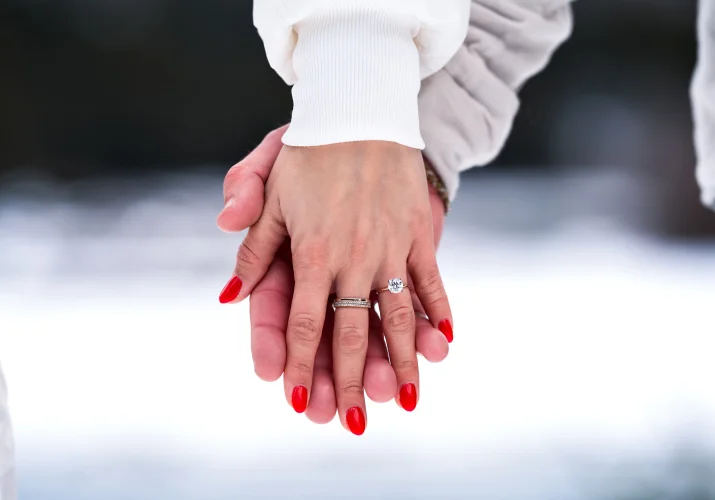 holding hands with an engagement ring