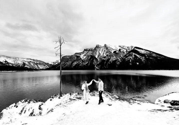 Banff's Winter Wonderland of engaged couple dancing by the Minnewanka Lake