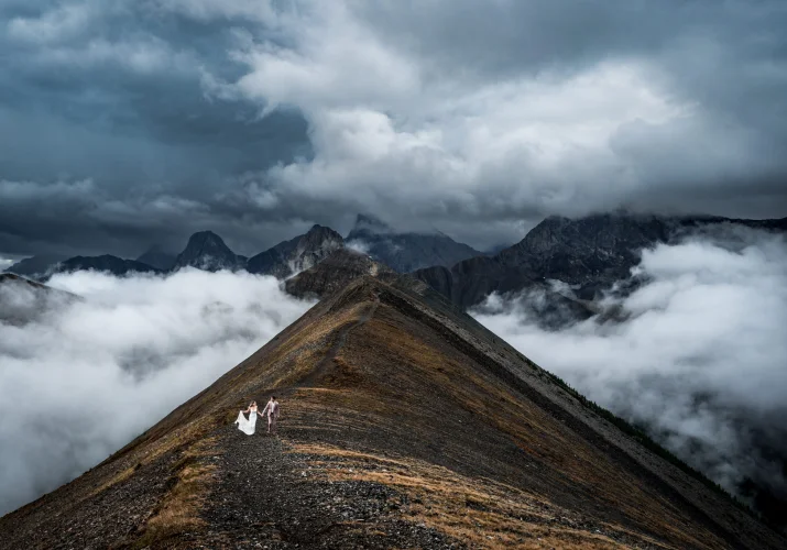 Bride and groom walk on the ridge