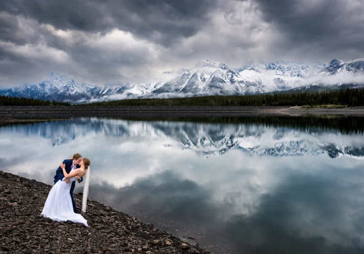 Two brides kiss at the lakeshore