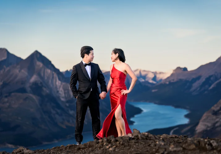 Newlyweds pose on the top of the mountain