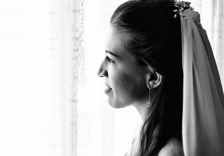 Bride looks through the window before wedding ceremony in Banff