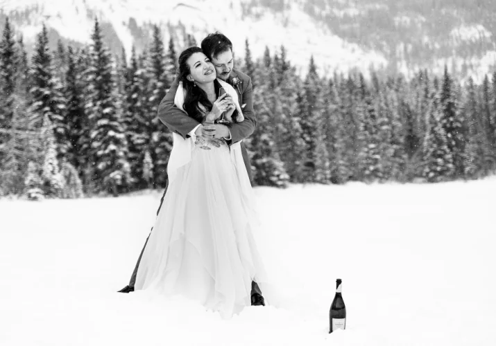 Groom hugging the bride during winter photo session in Kananaskis Alberta