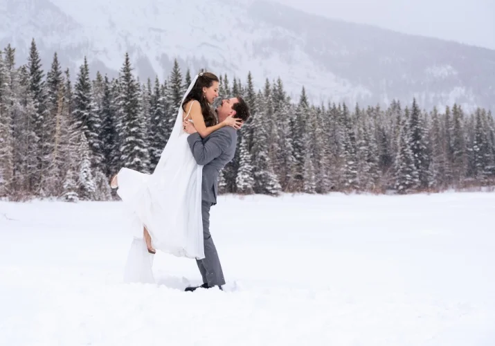 The groom lifting his wife and looking into her eyes in during winter photo session with 4eyes photography