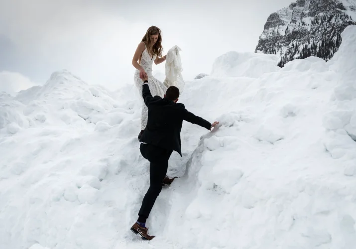Newlyweds are climbing the mountain in Banff