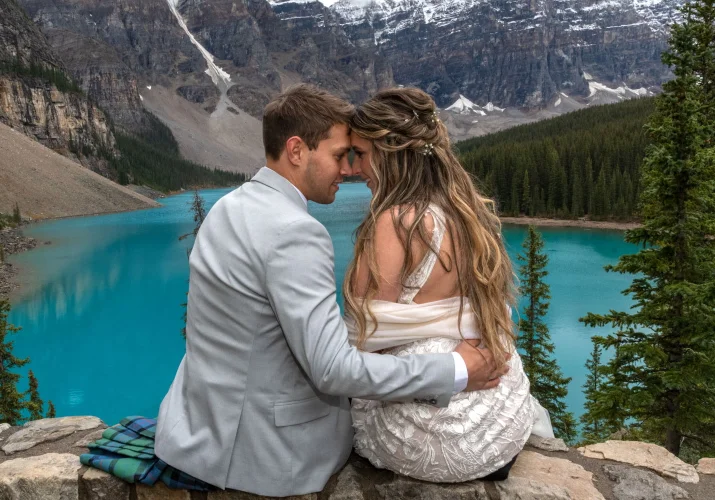Groom and bride in intimate moment while touching foreheads and looking at each other