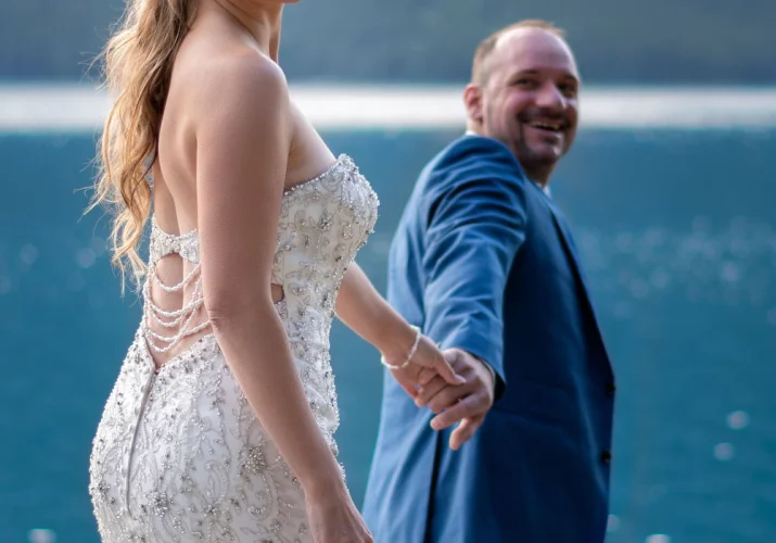 Groom leads his bride by hand during Banff after wedding shoot.