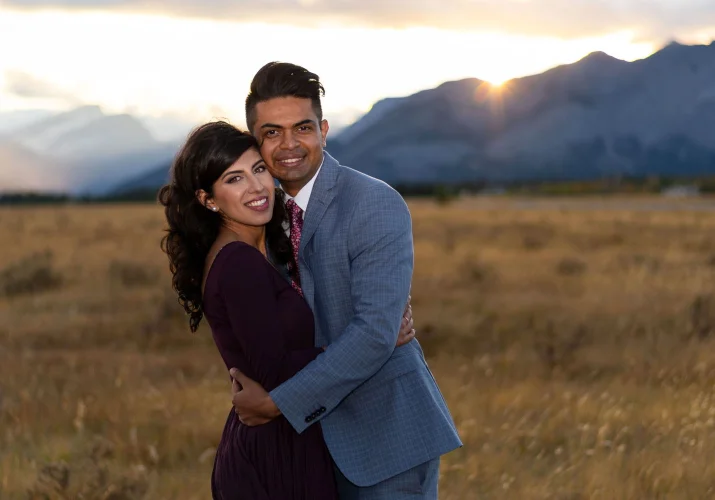 Engaged couple hugging each other with a smile on their faces.