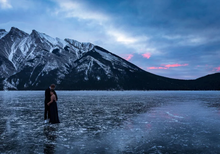 Engaged couple is hugging each other during frosty morning in Banff.