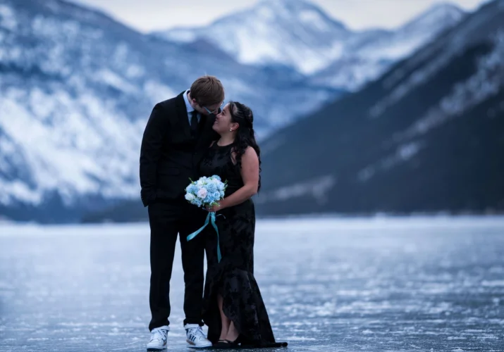 People in love look at each other. The girl holds blue flowers from her fiancée.