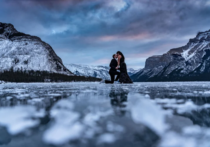 Engagement photo session during stunning sunrise in Banff. A man is proposing on one knee.