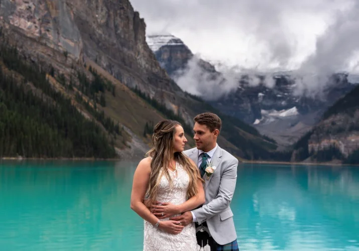 Scottish groom hugging his wife at the lake in Canadian Rocky Mountains