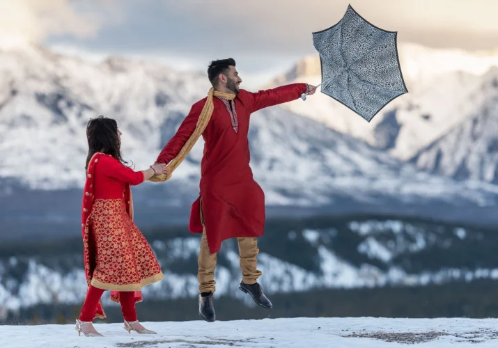 Indian Couple strrugle with strong wind during after wedding session in Banff.