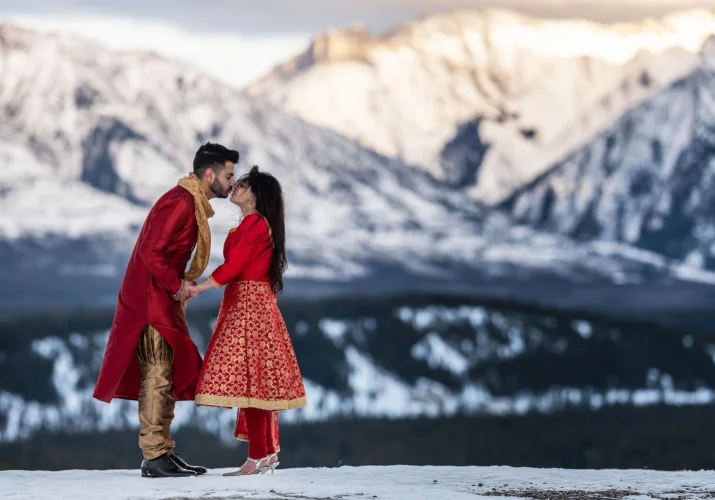 Indian Wedding in Banff. Newlyweds are kissing during wedding ceremony in Banff.