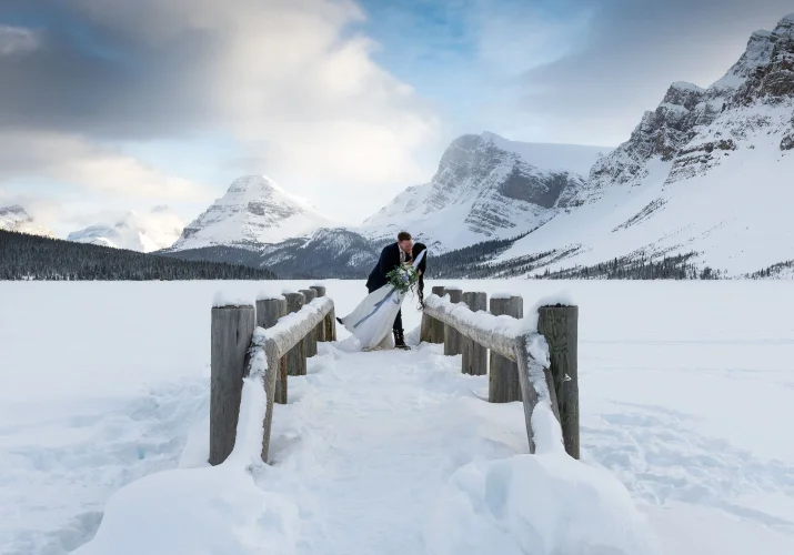 Groom are kissing the bride on the bridge after wedding ceremony in Banff.