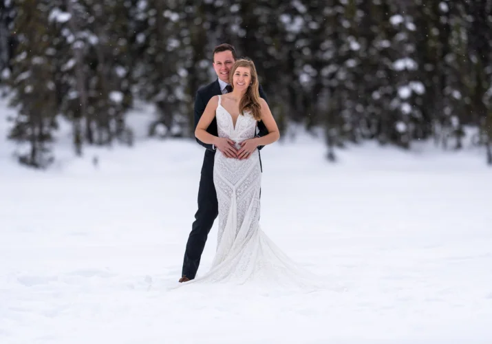 Newlyweds smiling at the camera at their wedding day at Lake Louise
