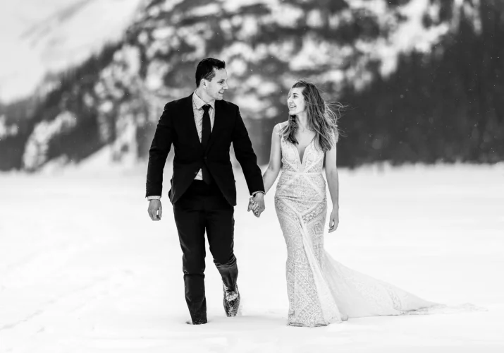 Married couple are walking during their after wedding photo session at Lake Louise
