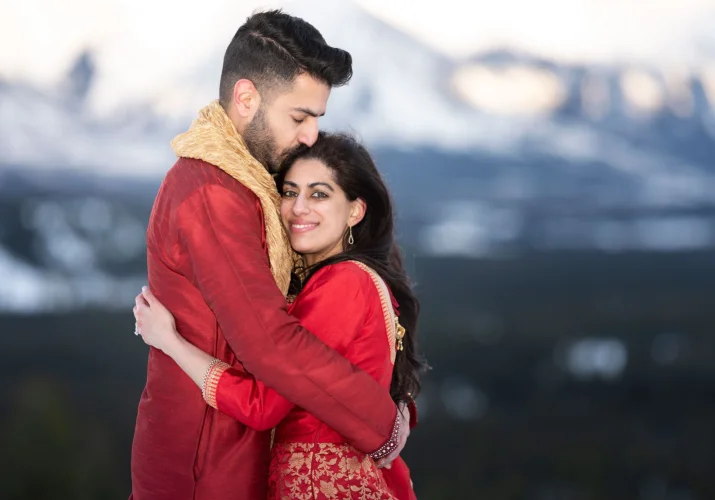 Indian groom and bride hugs during after wedding photo session.