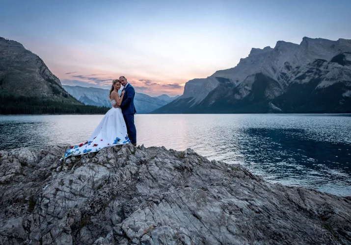 Newlyweds hugging each other during after wedding photo shoot at Minnewanka Lake.