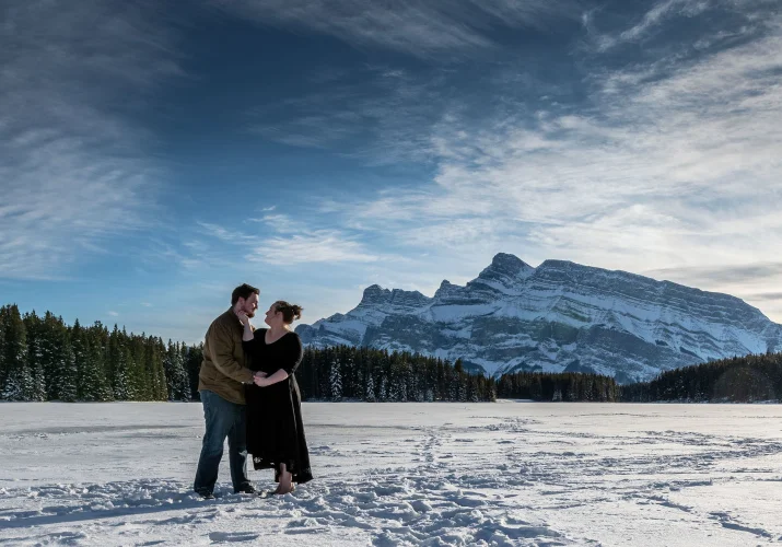 Couple in love look deaply into their eyes during winter photo session at Two Jack Lake.