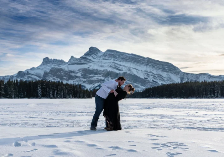 Coulpe in love dancing during mountain engagement photo session at Two Jack Lake in Banff.