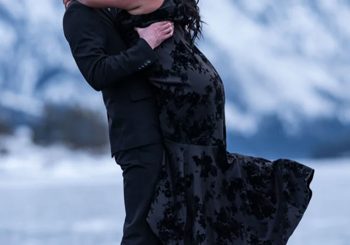 Happy fiancé is holding his future wife after his proposal. They look at each other with love.