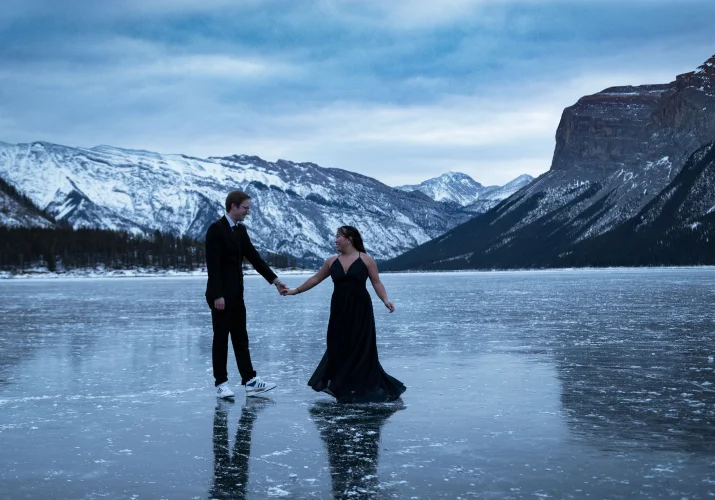 Newly engaged couple is dancing at the frozen lake in Banff during their engagement session.