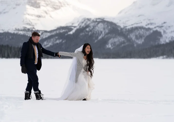 Newlyweds walks in deep snow on their wedding at Bow Lake