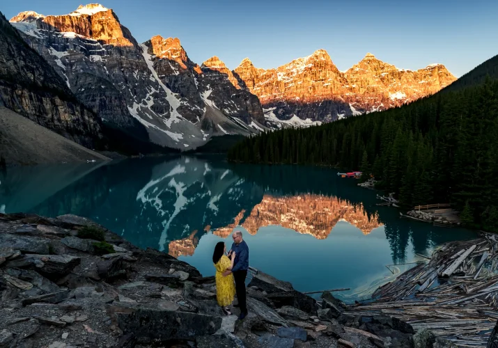Couple in love look at the beauty of sunset at Moraine lake during their engagement photo session