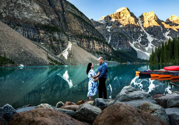 Happily engaged couple looking at each other with love in Banff Moraine Lake