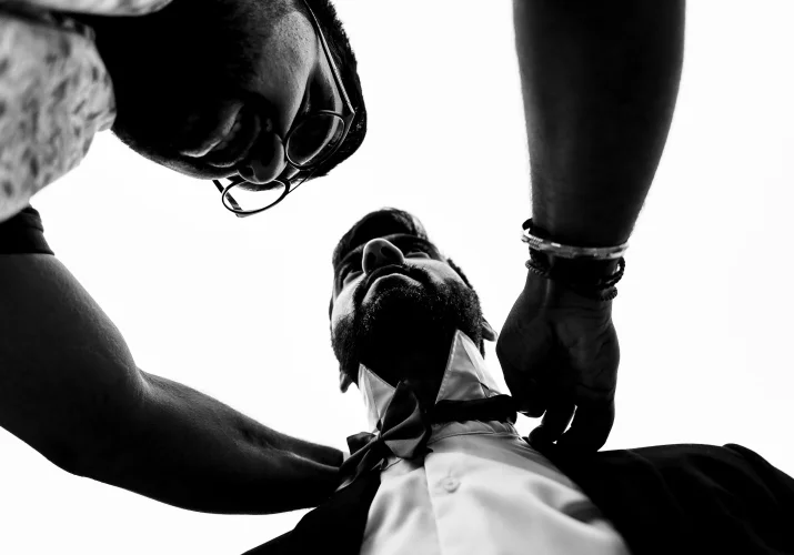 Best men is helping the groom to fix the tie