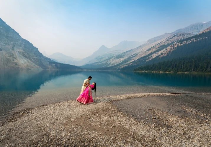 Indian lovers dancing at Bow Lake surrounded by gorgeous Canadian Rockies.