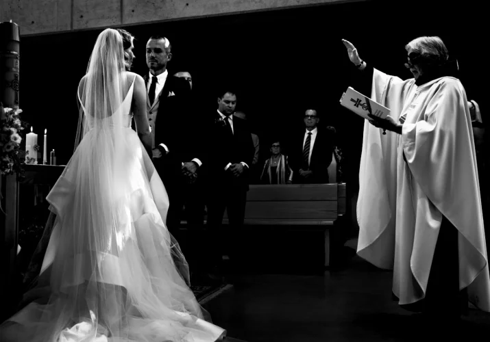 The priest is giving a blessing to the Bride and groom. Important oments are being captured by talented Calgary Wedding photographers.