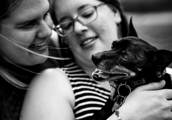 Happy couple look at their dog.