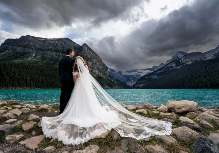 Couple in love admire gorgeous view at Lake Louise. Special moment it captured by the best Banff Wedding Photographer.
