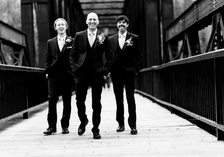 Groom and best man posing at the bride to the best Calgary Wedding Photographer