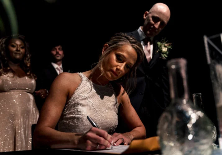 Calgary wedding photographer capturing signing the wedding papers by bride