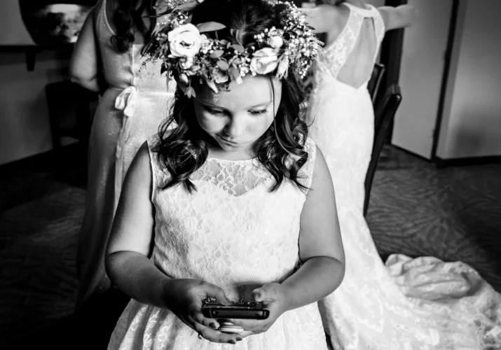 Flower girl is playing with her cellphone during Calgary Getting Ready Time