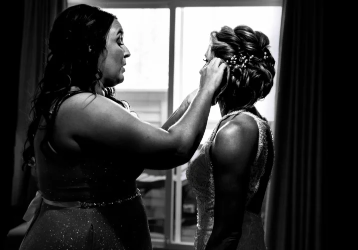 Bride's maid helping the bride with her earrings